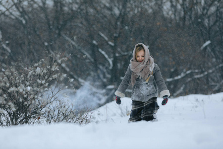 可爱的小女孩在树林里的冬天。下雪