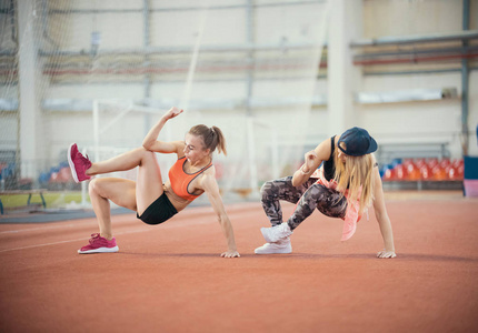 两个年轻的运动女子在锻炼。同步进行移动