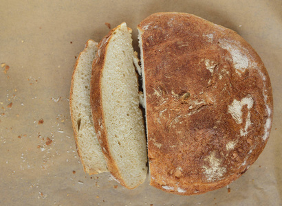从上面可以看到半条新鲜的家庭面包，从上面切下来，在羊皮纸上烤面包屑，用来烤新鲜面包屑