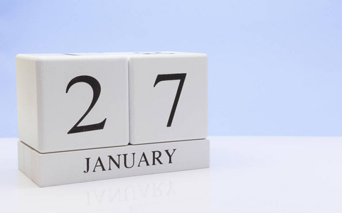 一月二十七日 月27日每日日历在白色桌子上，反射浅蓝色背景。 冬天的时间空的空间