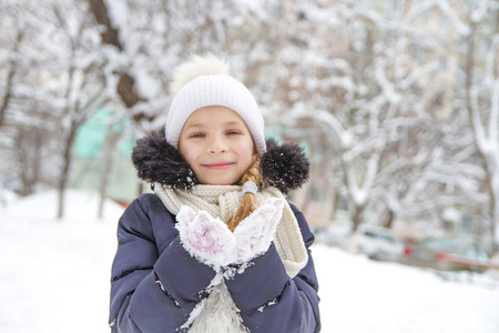 微笑的女孩在冬天公园玩雪