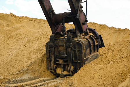 一个巨大的挖掘机斗在采砂场挖掘沙子