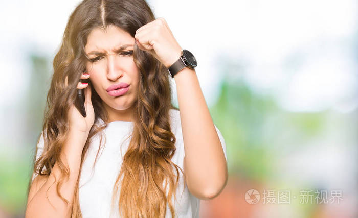 年轻的成年女人拿起电话,愤怒,沮丧,愤怒,疯狂的喊叫和举起手的愤怒