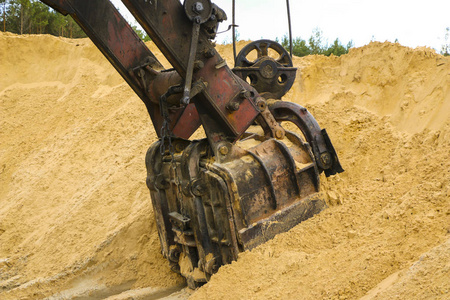 一个巨大的挖掘机斗在采砂场挖掘沙子
