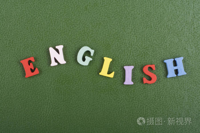 绿色背景上的英文单词由五颜六色的abc字母组成,木制字母,复制空间为