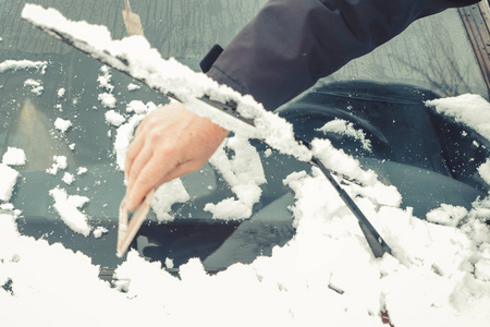 下雪后司机打扫他的车