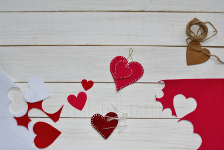 做情人节礼物。2月14概念。两颗木头心绑着绳子，许多红色的心和一颗心在白色老式的木制背景上未完成。文字空间。