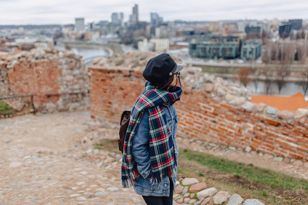 穿着牛仔裤夹克的时髦女孩走在基迪米纳斯城堡立陶宛的维尔纽斯背景下