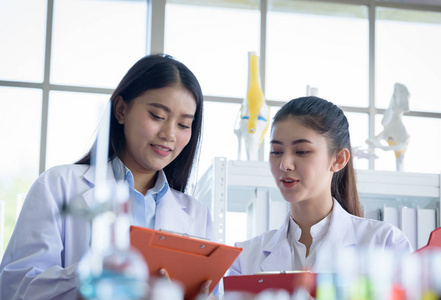 亚洲年轻女性一起工作和研究科学家。