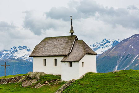 可爱的小老教堂在贝特梅拉普阿尔卑斯山山村瑞士。 夏天多云的景色。