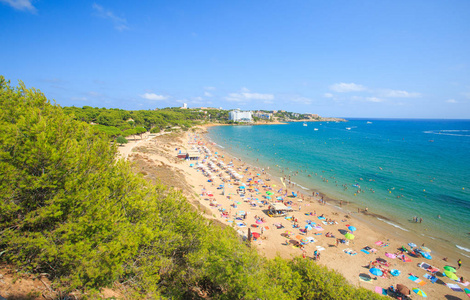 萨卢西班牙。 在Salou度假村带游客的海滩。 西班牙的科斯塔多拉达地区。 夏季旅游背景。