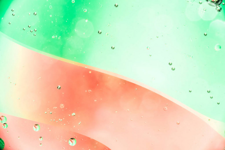 水中的油泡靠近红色绿色背景，彩色抽象背景