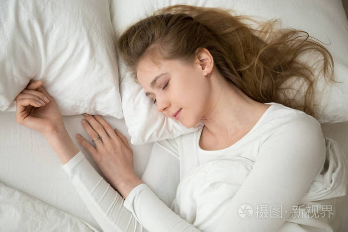 宁静的年轻女子躺在舒适的床上睡得很好照片-正版商用图片18nu77-摄图