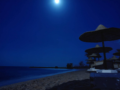晚上在海滩上拿着草伞。 埃及