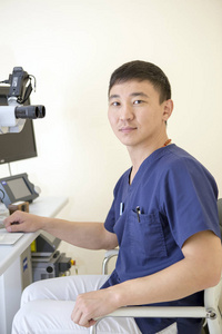 亚洲男性眼科医生正在他的工作场所工作