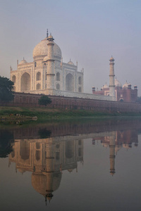 泰姬陵的景色与清晨的雾反映在雅穆纳河阿格拉北方邦印度。 泰姬陵于1983年被指定为联合国教科文组织的世界遗产地。