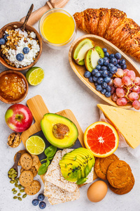 白色背景下健康平衡早餐。 梅斯利果汁牛角面包奶酪饼干和水果的顶部视图。