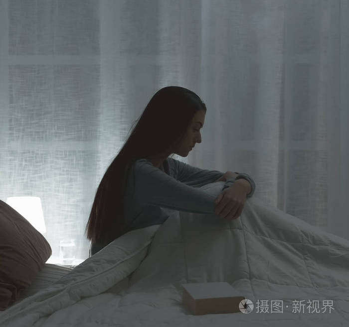 伤心沮丧的女人深夜躺在床上,失眠,精疲力竭