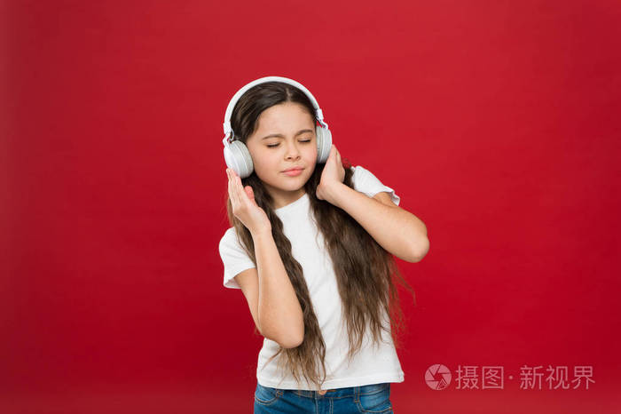 戴立体声耳机的小女孩.小女孩听音乐.带无线耳机的可爱音乐风扇.
