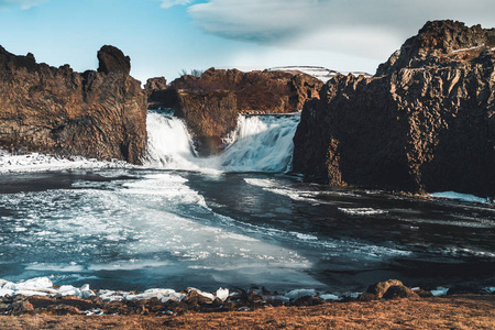 著名的 hjalparfoss 双瀑布在冰岛南部与天空和云。在冰岛徒步。旅游和景观摄影概念