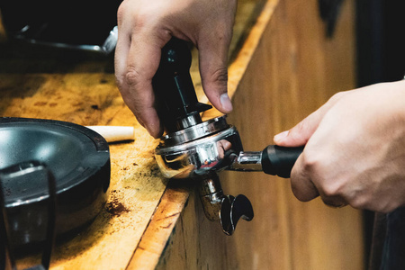 咖啡师在咖啡店工作，咖啡师用捣碎机将咖啡磨碎，咖啡师制作咖啡壶概念