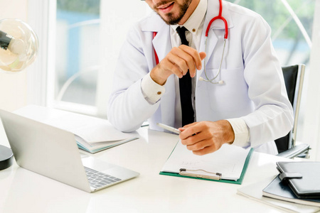 医生在医院的办公桌上用笔记本电脑工作。 医疗和保健概念。