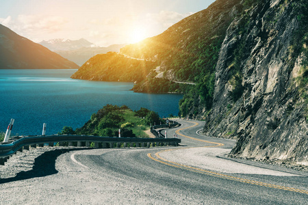 新西兰南岛皇后镇沿山崖和湖泊景观蜿蜒曲折的道路。 夏天的旅行和公路旅行。