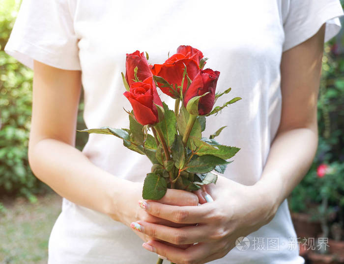 在花园里拿着红玫瑰的女人照片-正版商用图片18pt09