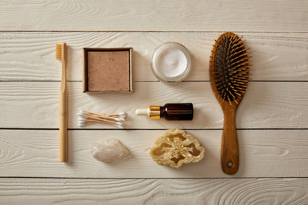 白色木制表面的各种卫生和化妆品的顶部视图，零浪费概念