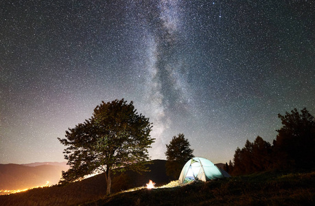 闪耀的帐篷和篝火在惊人的夜空下充满了星星和银河