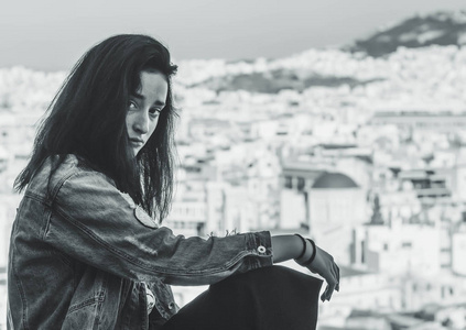 希腊雅典阿纳菲蒂卡旅游区城市全景背景下的年轻希腊女孩
