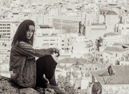希腊阿那菲奥蒂卡旅游区城市全景背景下的年轻希腊女孩