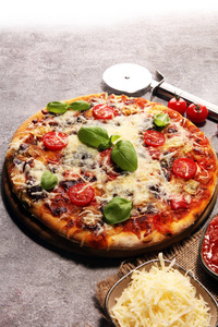 意大利素食比萨饼，上面有融化的奶酪红西红柿和绿罗勒，由奶酪番茄和红樱桃西红柿装饰。