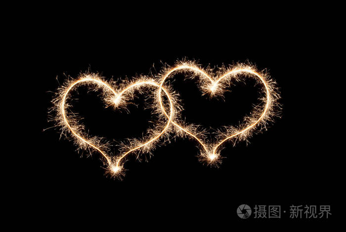 两颗心是由黑色背景上的火花制成的爱的象征