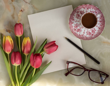 贺卡一束美丽的鲜花春天的郁金香酒杯和大理石背景上的咖啡