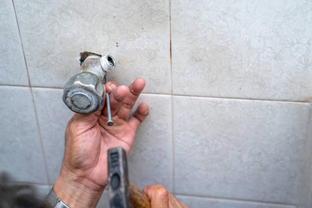 亚洲人试图在旧洗手间修理和修理管道淋浴。