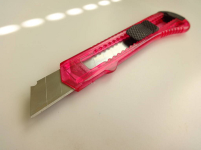 孤立的粉红色纸刀