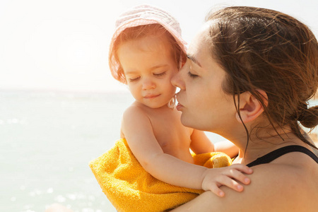在阳光明媚的日子里，母亲和她的小女儿在户外拥抱，积极的人类情感感情情感。假期幸福家庭肖像