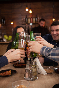 一群快乐的朋友在啤酒厂酒吧餐厅喝啤酒和敬酒