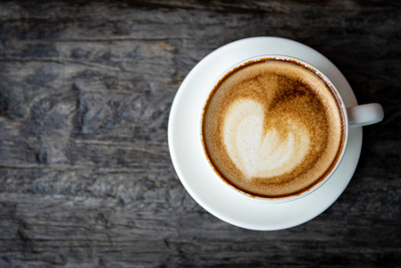 形状的心在咖啡的早晨，在旧的木桌上。 生活方式概念