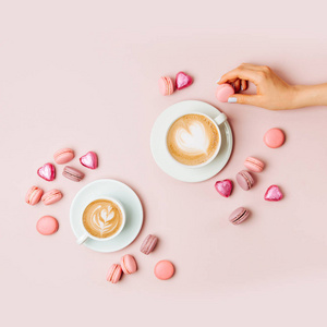 s hands  holding cup of coffee on pale pink background.   Flat l