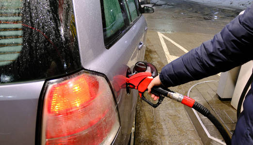 男子在加油站的汽车上泵送汽油燃料，运输和所有权概念