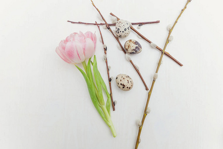 春天的贺卡。 复活节彩蛋，棉柳枝和粉红色新鲜郁金香花束在乡村白色的木制背景上。 复活节的概念。 平躺顶部视图复制空间。 春花郁金