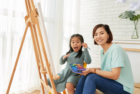 快乐的小越南女孩和她的护士喜欢在画布上画画