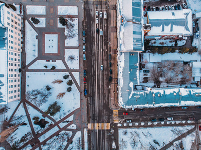 冬季城市无人机的空中射门, 从雪道路汽车交通和建筑物上到下的视野