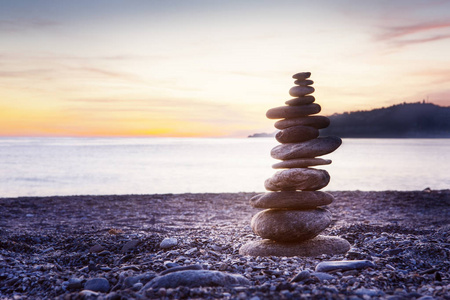 岩石平衡或石头Balancin自然平衡在海滩上，后面是海