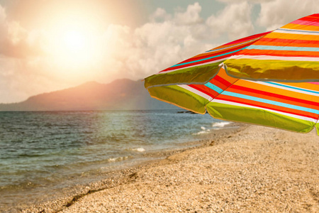日落时带彩色雨伞的海滩。