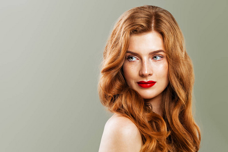 年轻漂亮的红头发女人。 红发女孩，绿色背景的姜黄色卷发