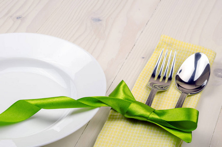 用绿色丝带装饰的餐叉和餐刀图片