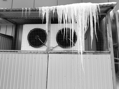 冰和冰柱挂在冰冷的空调上图片